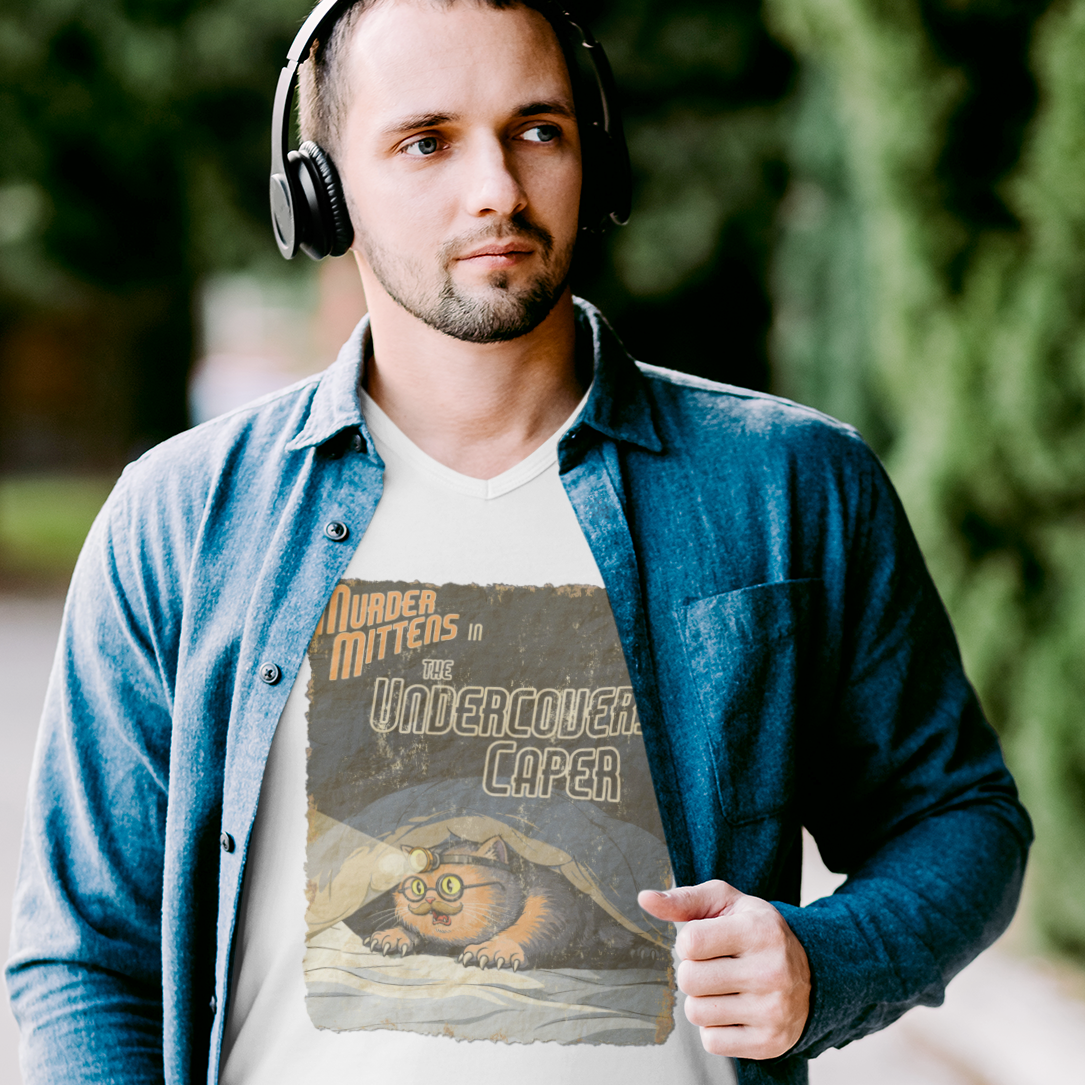 A man wearing a white graphic t-shirt that reads, 'Murder Mittens in The Undercovers Caper'.