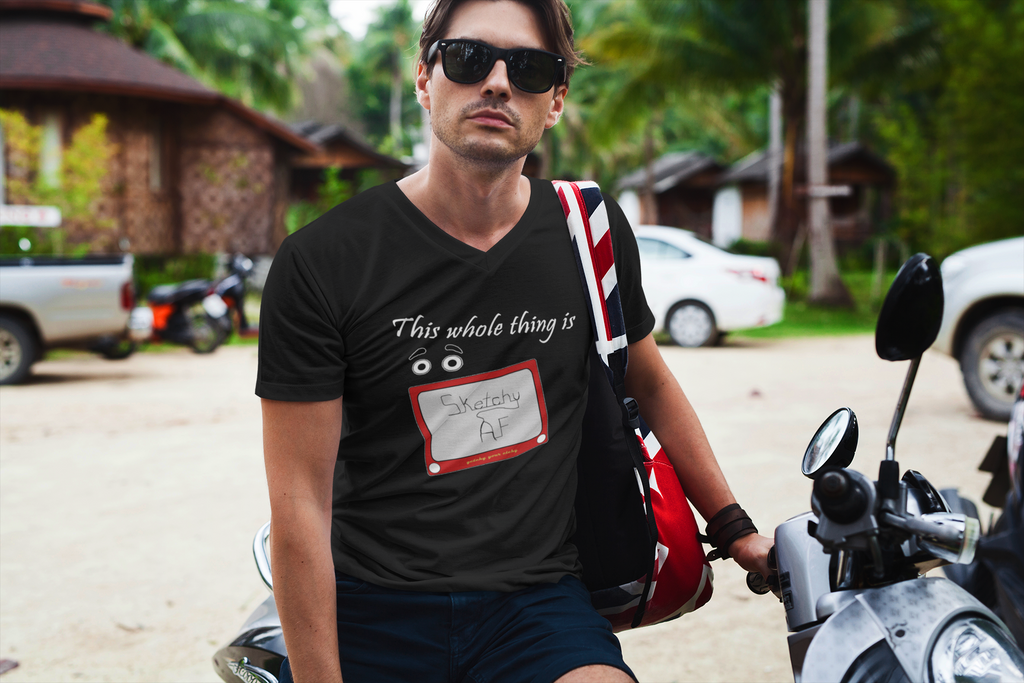 A man wearing a black v-neck t-shirt with the slogan, 'This whole thing is' above a pair of googly eyes, all above a retro red drawing toy with the words 'Sketchy AF' on the screen.